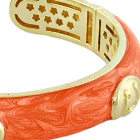 Orange marbled enamel with a gold medallion, magnified